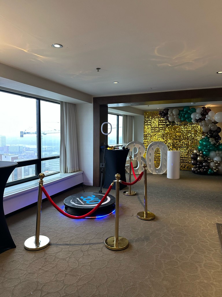 Quinte West 360 booth with stanchions, balloon decor, marquee numbers and a backdrop