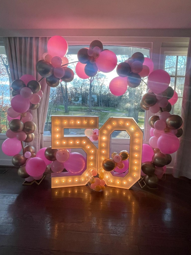 Quinte West balloon arch framing marquee numbers.