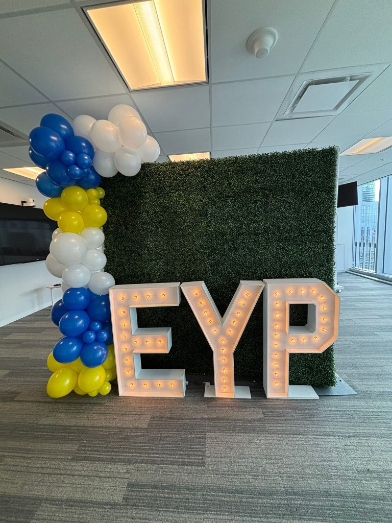 green boxwood wall in port stanley with marquee letters and a balloon garland